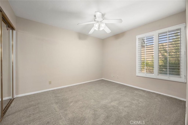 unfurnished bedroom with ceiling fan, a closet, and carpet