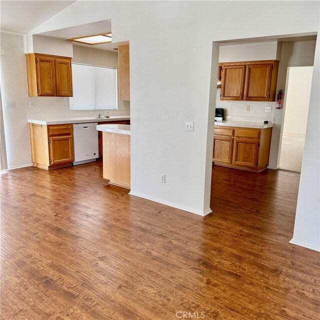 kitchen featuring dark wood-type flooring, backsplash, dishwasher, and sink