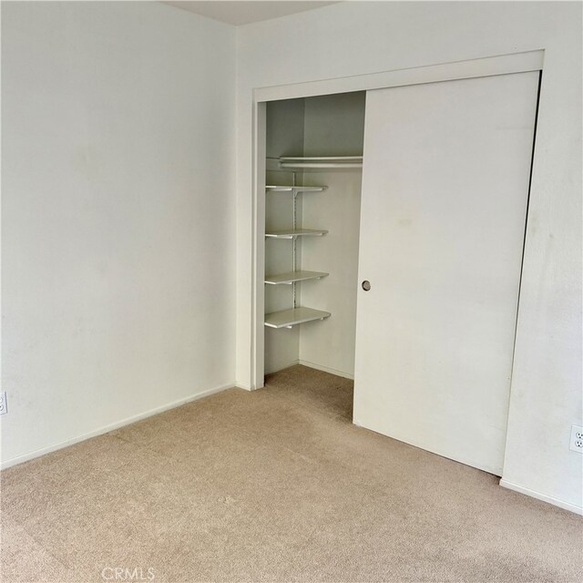 unfurnished bedroom with a closet and carpet flooring