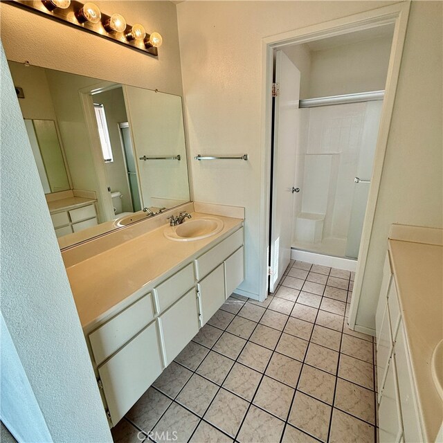 bathroom featuring vanity, tile patterned flooring, and walk in shower