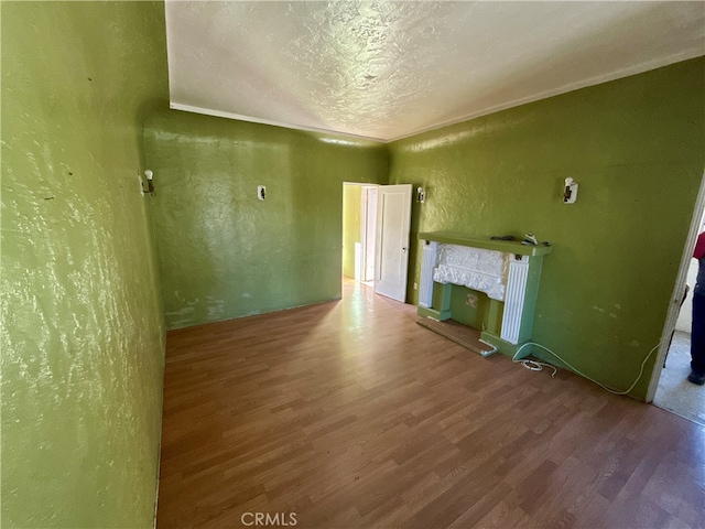 empty room with hardwood / wood-style floors and a textured ceiling