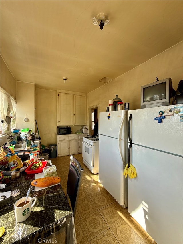 kitchen featuring white cabinetry and white appliances