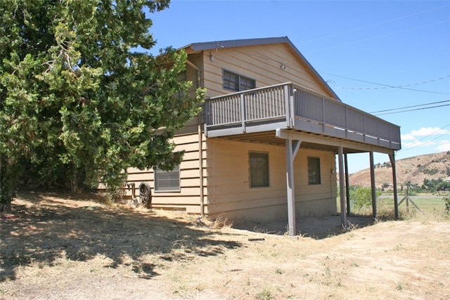 rear view of house featuring a deck with mountain view