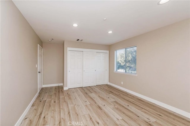 unfurnished bedroom featuring light hardwood / wood-style floors and a closet