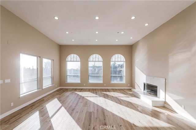 unfurnished living room with a healthy amount of sunlight and light hardwood / wood-style flooring