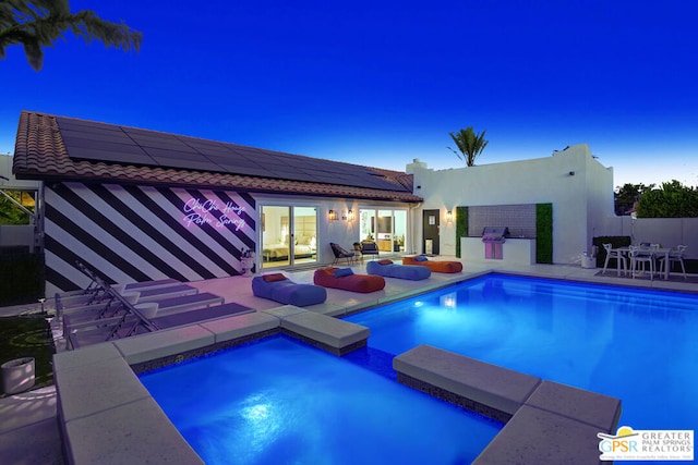 pool at dusk with a patio