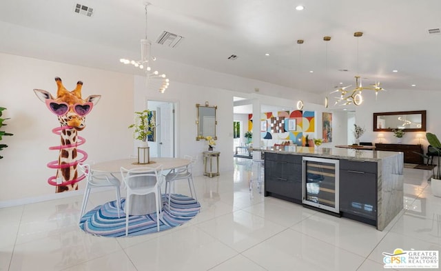 kitchen featuring a spacious island, light tile patterned flooring, beverage cooler, and hanging light fixtures