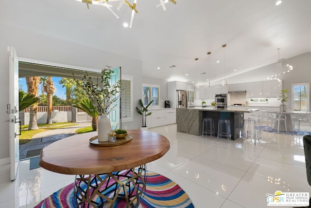 dining room with lofted ceiling and light tile patterned flooring