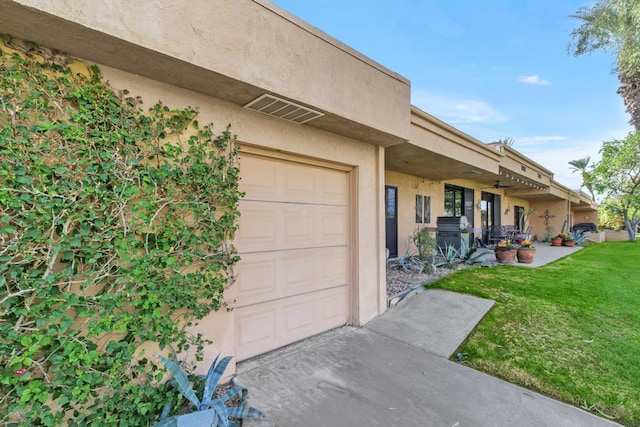 exterior space featuring a garage and a lawn