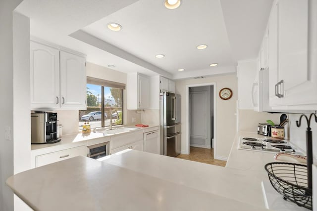 kitchen with white cabinets, white appliances, and kitchen peninsula