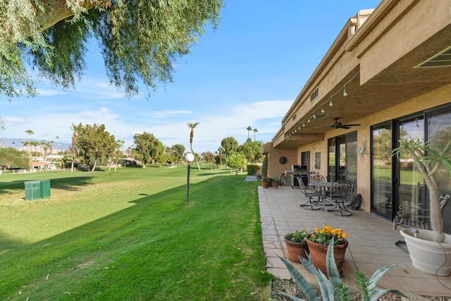 view of yard with a patio area and ceiling fan