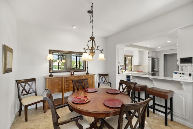 tiled dining room with sink and an inviting chandelier