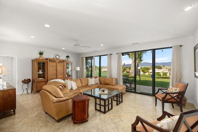 living room with light tile patterned flooring, a wealth of natural light, ceiling fan, and a mountain view