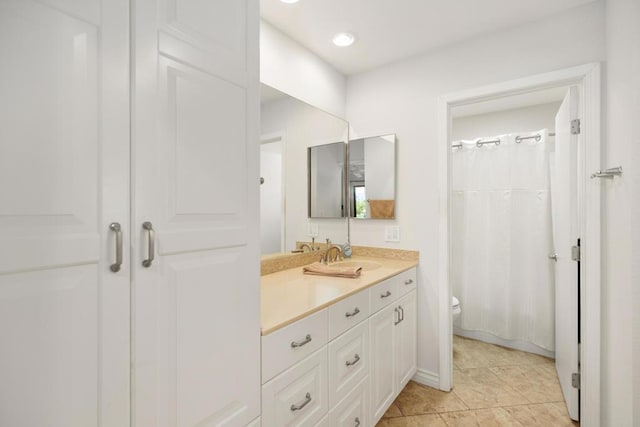 bathroom with tile patterned floors, vanity, curtained shower, and toilet