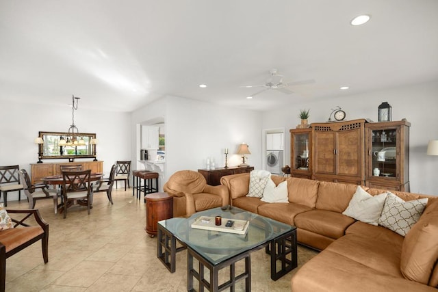 living room featuring light tile patterned floors, ceiling fan with notable chandelier, and washer / dryer