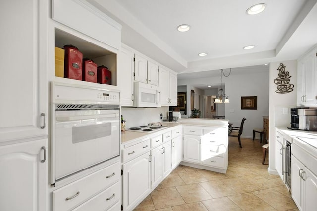 kitchen with white cabinetry, decorative light fixtures, and white appliances