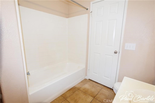 bathroom featuring bathtub / shower combination, toilet, and tile patterned flooring