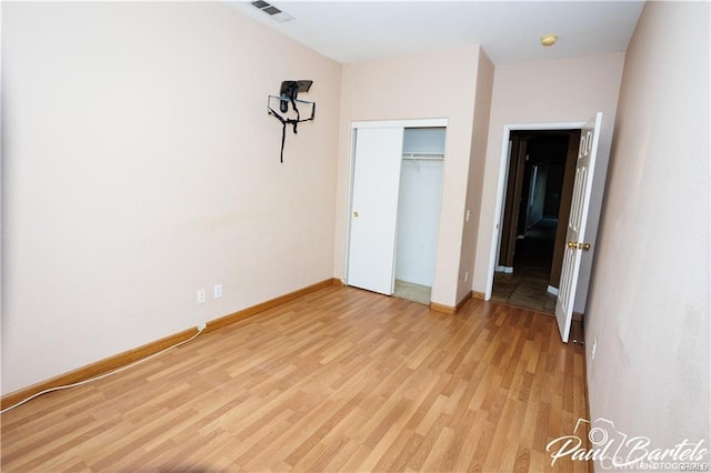 unfurnished bedroom with light hardwood / wood-style floors and a closet