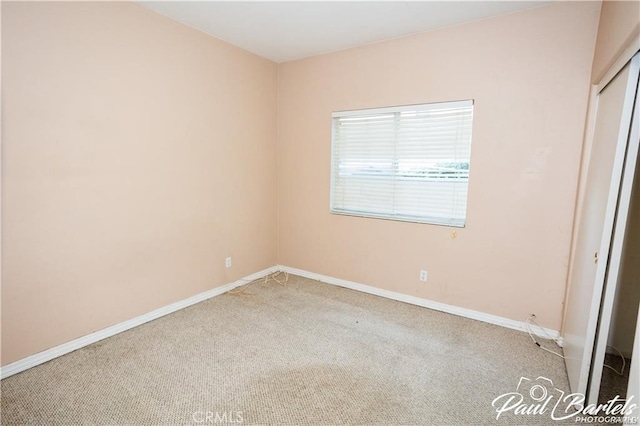 unfurnished bedroom with light carpet and a closet