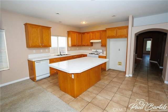 kitchen featuring light tile patterned floors, a center island, sink, and white appliances