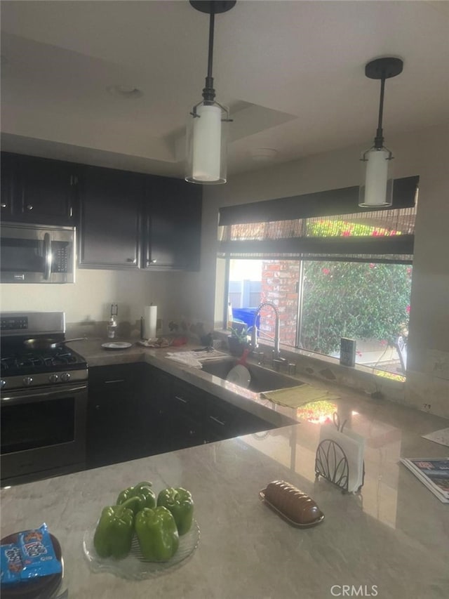 kitchen featuring sink, pendant lighting, and appliances with stainless steel finishes