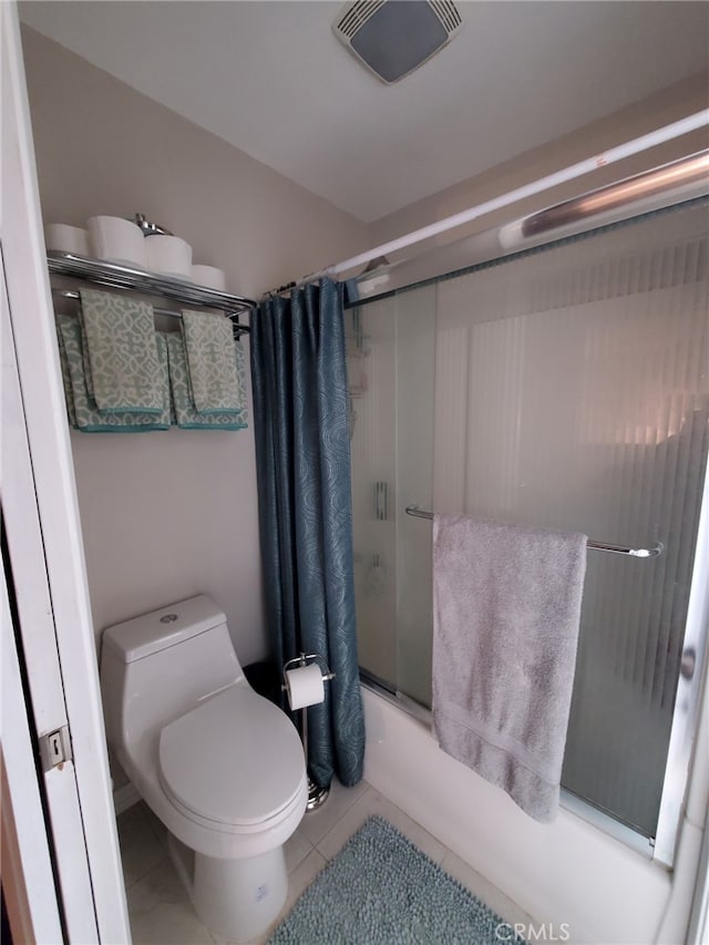 bathroom with toilet, shower / bath combo with shower curtain, and tile patterned floors