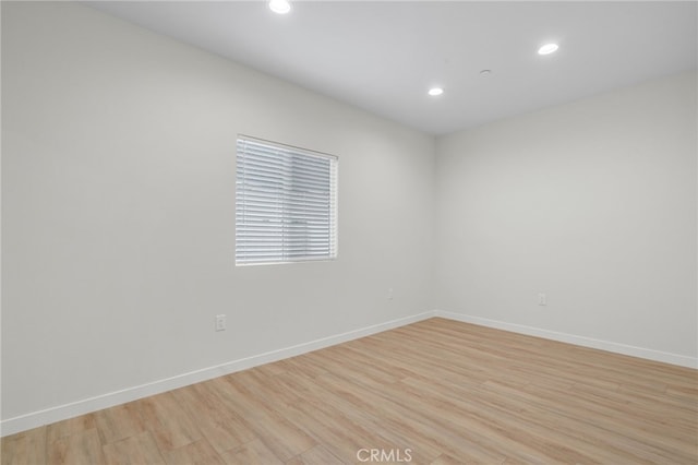 spare room with light wood-type flooring, baseboards, and recessed lighting