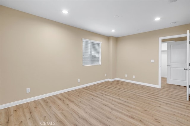 unfurnished room with recessed lighting, light wood-style flooring, and baseboards