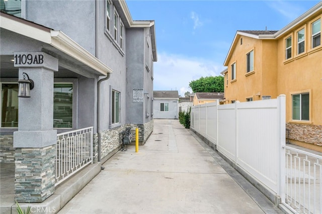 view of side of home with fence and stucco siding