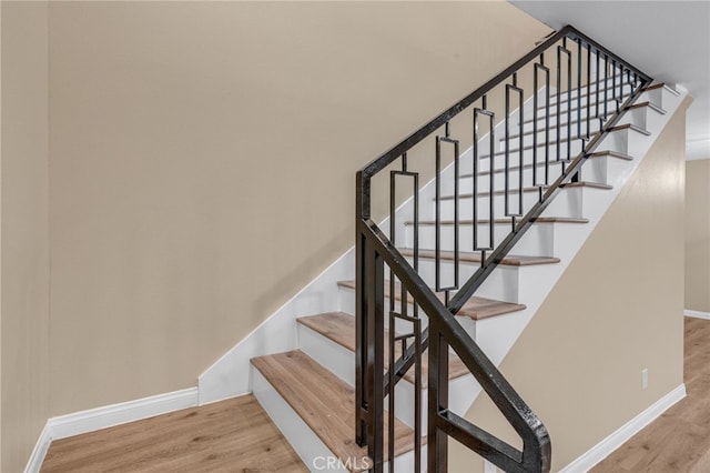 staircase with hardwood / wood-style floors