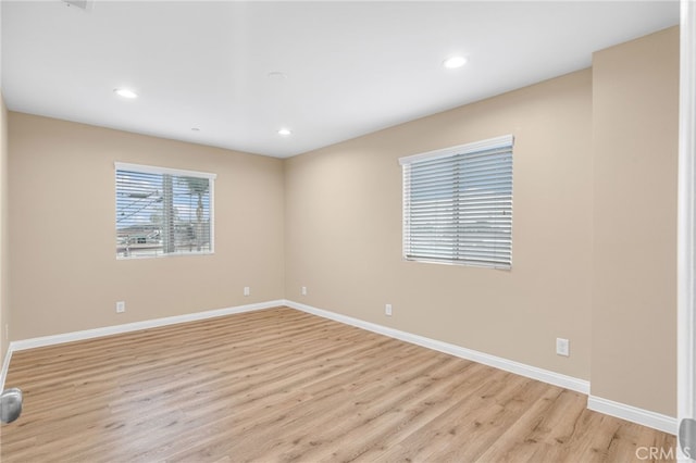 empty room with light wood finished floors, baseboards, and recessed lighting