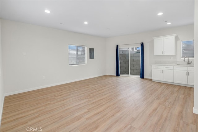 unfurnished living room with sink and light hardwood / wood-style flooring