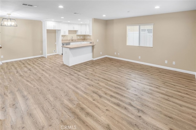 unfurnished living room with sink and light hardwood / wood-style flooring