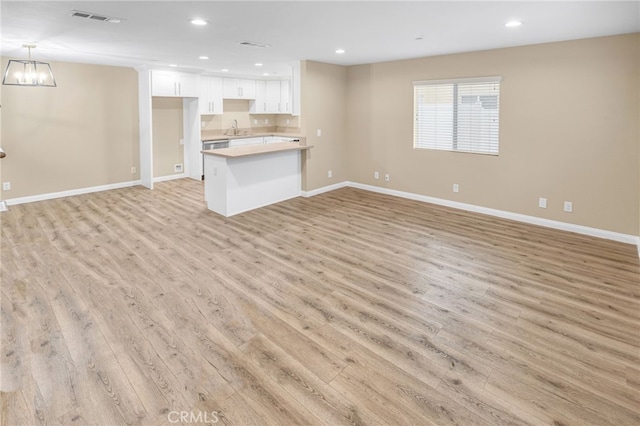 unfurnished living room featuring light wood-style flooring, visible vents, baseboards, and recessed lighting