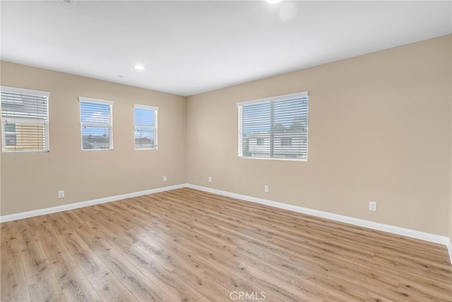 empty room with a wealth of natural light and baseboards