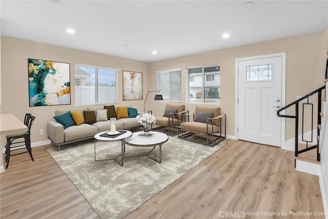 living area featuring baseboards, stairway, recessed lighting, and light wood-style floors