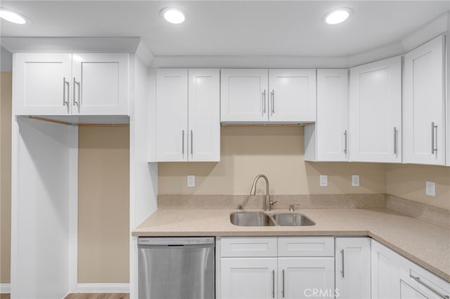 kitchen with light countertops, a sink, stainless steel dishwasher, and white cabinetry