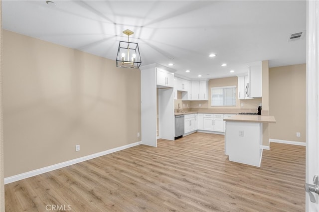 kitchen with visible vents, white cabinets, light countertops, stainless steel dishwasher, and a kitchen bar