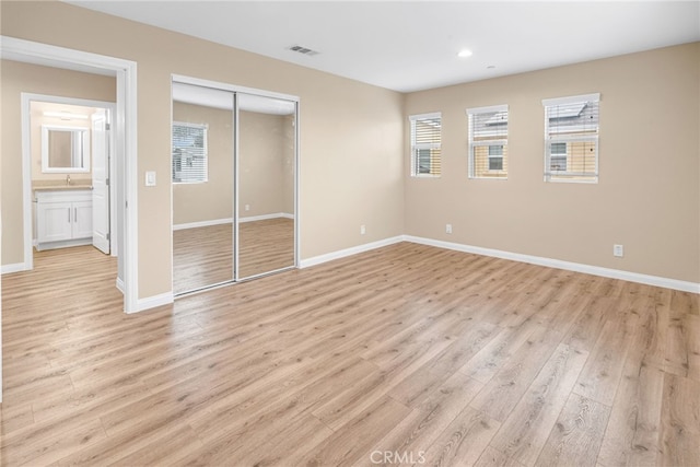 unfurnished bedroom with a closet and light hardwood / wood-style flooring