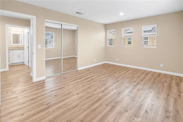 unfurnished bedroom featuring recessed lighting, a closet, visible vents, light wood-style floors, and baseboards