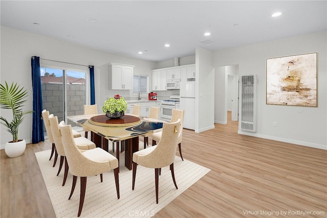 dining space with sink and light hardwood / wood-style floors