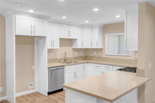 kitchen featuring white cabinets, kitchen peninsula, sink, and stainless steel appliances