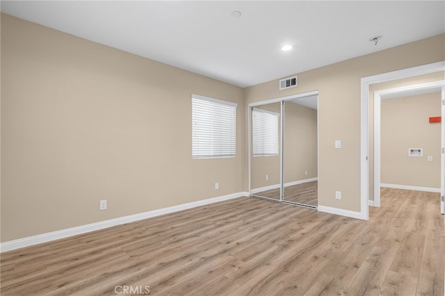 unfurnished bedroom with recessed lighting, visible vents, baseboards, a closet, and light wood-type flooring