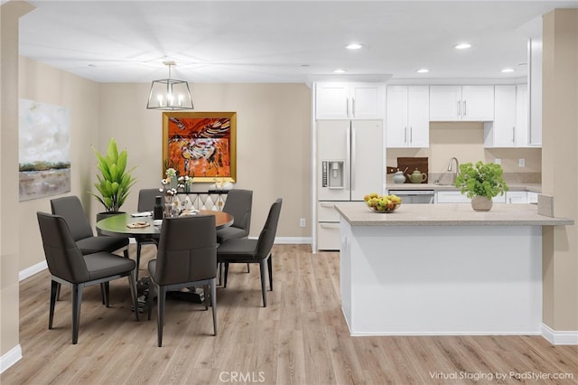 dining room featuring light wood-style flooring, baseboards, and recessed lighting