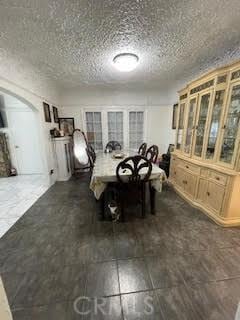 unfurnished dining area with dark hardwood / wood-style flooring and a textured ceiling