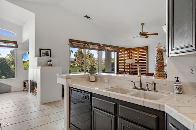 kitchen with tile counters, dishwasher, a healthy amount of sunlight, and sink