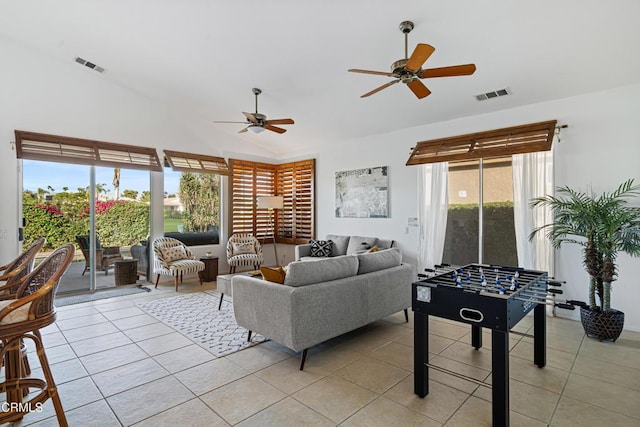 living room with ceiling fan, light tile patterned floors, and vaulted ceiling