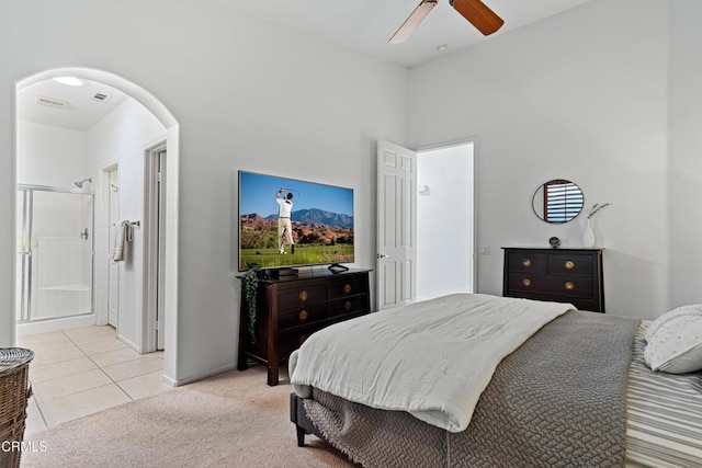 bedroom featuring light carpet, connected bathroom, and ceiling fan