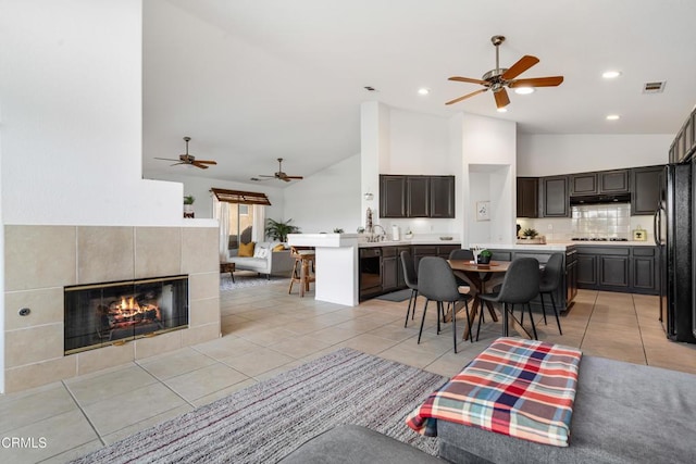 tiled living room with a fireplace and high vaulted ceiling