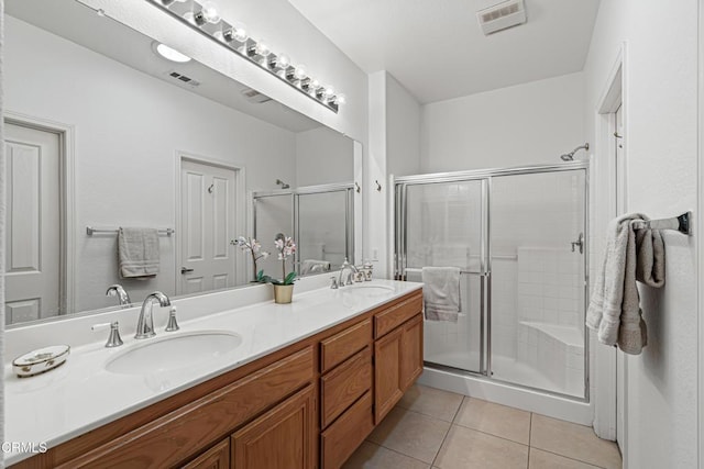 bathroom with tile patterned floors, a shower with door, and vanity